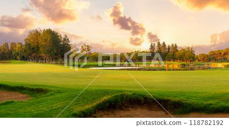 Picturesque panoramic view of golf course with bunker. Golf course at sunset with beautiful sky Picturesque panoramic view of golf course with bunker. Golf course at sunset with beautiful sky 118782192