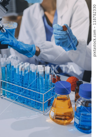 Scientist using microscope in laboratory. Close-up of a researcher's hands adjusting a modern microscope in a lab setting. Science concept 118782330