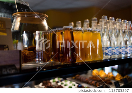 A cafe window with neatly displayed rows of glass bottles of juice and water A cafe window with neatly displayed rows of glass bottles of juice and water 118785297