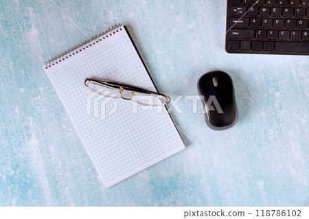 Modern office table includes notebook, glasses, mouse keyboard place to work. 118786102