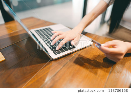 Woman hand consumer using creadit card and laptop on wooden table Woman hand consumer using creadit card and laptop on wooden table 118786168