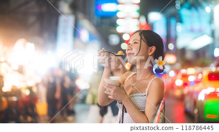Happy asian tourist woman eating thai tasty dessert at China town asia street food market Bangkok, Thailand 118786445
