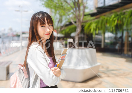 Beautiful young adult asian woman college student wear sweater and pink color backpack Beautiful young adult asian woman college student wear sweater and pink color backpack 118786781