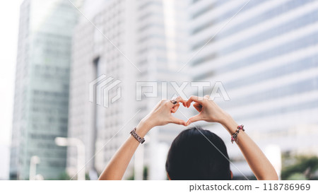 Rear view of single woman hand up with heart gesture wear silver accessory. Rear view of single woman hand up with heart gesture wear silver accessory. 118786969