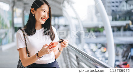 Young adult asian woman using credit card and smartphone for online shopping and digital wallet 118786975