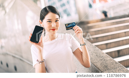 Young adult asian woman using credit card and smartphone for online shopping and digital wallet 118786976