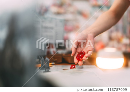Focus on hand rolling dice in role playing tabletop and board games hobby concept 118787099