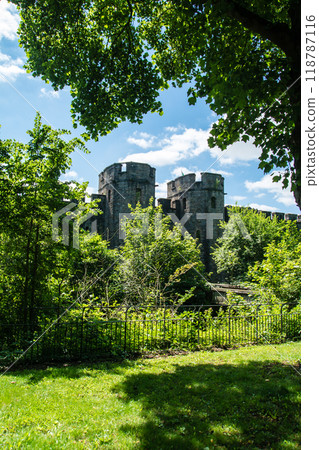 The tower and walls of Cardiff Castle surrounded by greenery under bright sunlight in Cardiff, the capital of Wales The tower and walls of Cardiff Castle surrounded by greenery under bright sunlight in Cardiff, the capital of Wales 118787116