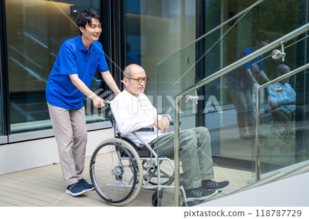坐輪椅爬樓梯有困難的老人和療養院工作人員 坐輪椅爬樓梯有困難的老人和療養院工作人員 118787729