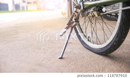 Wheel of a bicycle is flat parking on concrete sidewalk beside a road, need to be repaired, the moment of stillness and an unexpected pause in a journey. 118787910