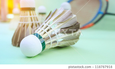 Closeup badminton shuttlecock and badminton racket on green background. Concept of enhance badminton lover and exercise. Closeup badminton shuttlecock and badminton racket on green background. Concept of enhance badminton lover and exercise. 118787918