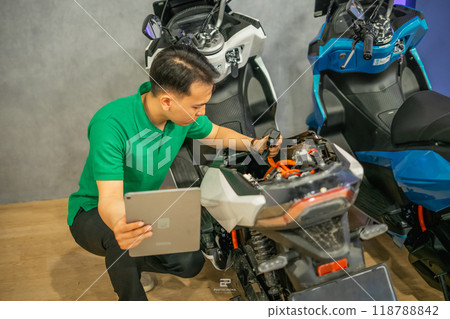 professional technician repairing electric motorbike using tablet professional technician repairing electric motorbike using tablet 118788842