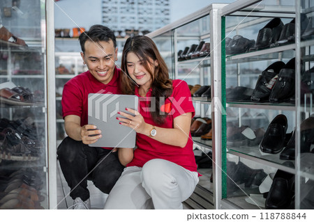 male and female leather shoes staff working together using tablet 118788844