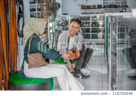 hijab woman customer helping partner choosing leather shoes hijab woman customer helping partner choosing leather shoes 118788846