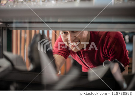 cropped view of asian employee putting leather shoes in display 118788898