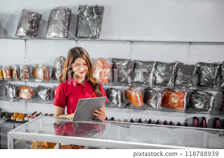 female employee working at leather apparel store using tablet female employee working at leather apparel store using tablet 118788939