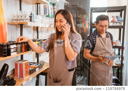 female staff getting phone call while checking product female staff getting phone call while checking product 118788978