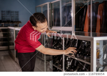 asian employee organize leather shoes and putting into shelves with happy face asian employee organize leather shoes and putting into shelves with happy face 118789054