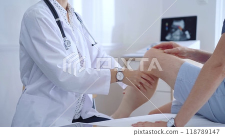 Doctor is carefully examining a patient's knee, providing personalized care and support. Medicine and orthopedic concept 118789147