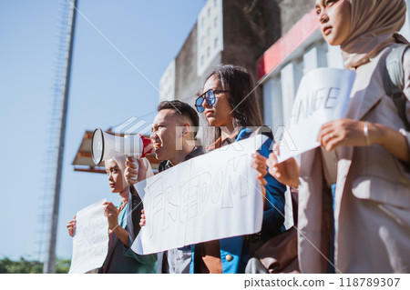 Activists are protesting passionately with megaphones and signs for social justice 118789307