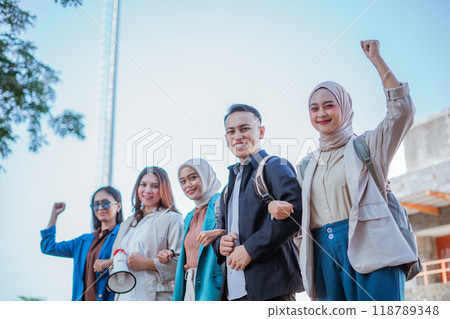 happy students holding hands together with raised fist happy students holding hands together with raised fist 118789348