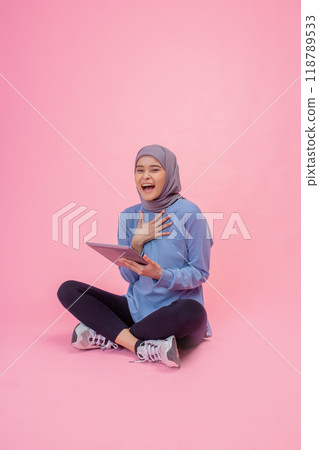 Joyful Young Woman Expressing Emotion While Sitting on Pink Background Joyful Young Woman Expressing Emotion While Sitting on Pink Background 118789533