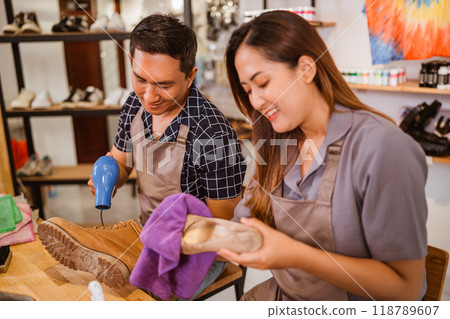 employees drying boots using hairdryer and rag 118789607