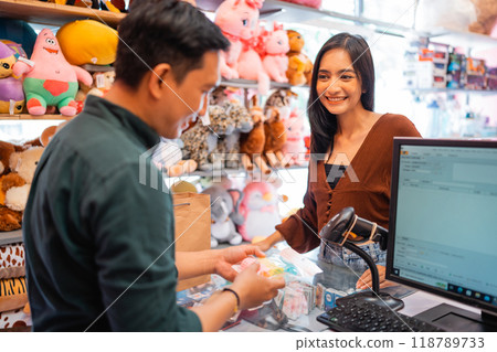 beautiful young woman smiling while paying for her groceries at cashier 118789733