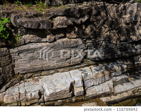 Detailed texture of layers and cracks in sedimentary rock formation 118789842