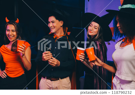 Joyful office Halloween party with coworkers in costumes, celebrating with drinks and laughter, fostering teamwork and festive spirit 118790232