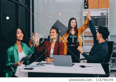 Young corporate employees sitting in office looking at laptop screen reading good news excited happy team diverse people celebrating victory win command success excellent result professional teamwork 118790299