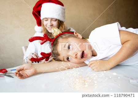 Merry Christmas Happy New Year Children in family are preparing for new year and having fun on table Merry Christmas Happy New Year Children in family are preparing for new year and having fun on table 118790471