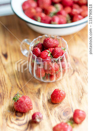 Strawberry harvest in a transparent cup on a wooden background, top view Strawberry harvest in a transparent cup on a wooden background, top view 118790618