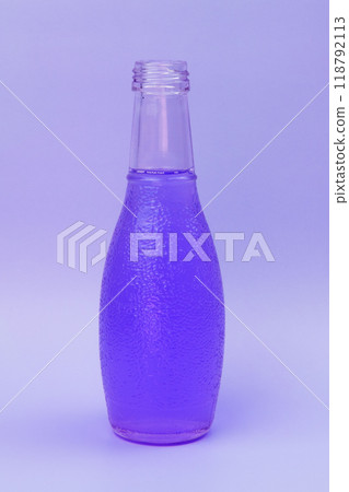 Transparent glass bottle with colorful liquid, unusual background Transparent glass bottle with colorful liquid, unusual background 118792113