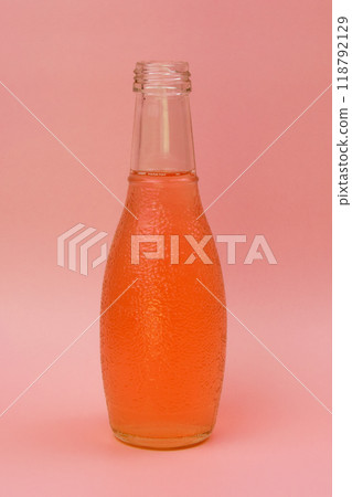 Transparent glass bottle with colorful liquid, unusual background 118792129