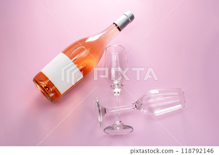 Wine bottle mockup, unopened bottle of rose wine and two glasses on pink background, top view, copy space, flat lay 118792146