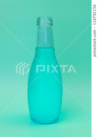 Transparent glass bottle with colorful liquid, unusual background Transparent glass bottle with colorful liquid, unusual background 118792156