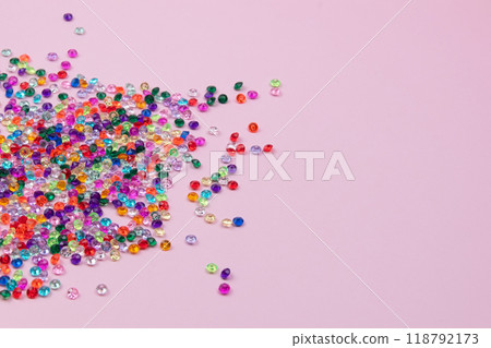 Multicolored tiny faceted crystals on a pink background, beautiful colorful texture 118792173
