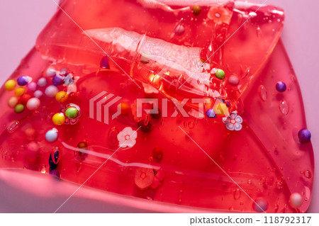 Colorful gel texture, clear skincare cream with bubbles and decorative figurines background, transparent beauty serum, colored cosmetic product close up 118792317