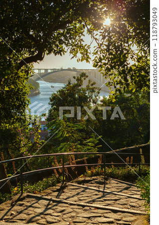 A rugged rocky shoreline meets the deep blue ocean under a sky 118793049