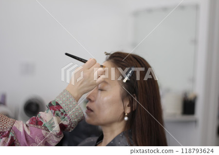 Concept of a beautiful Korean woman in her 30s getting her makeup done by a makeup artist, face before makeup Concept of a beautiful Korean woman in her 30s getting her makeup done by a makeup artist, face before makeup 118793624