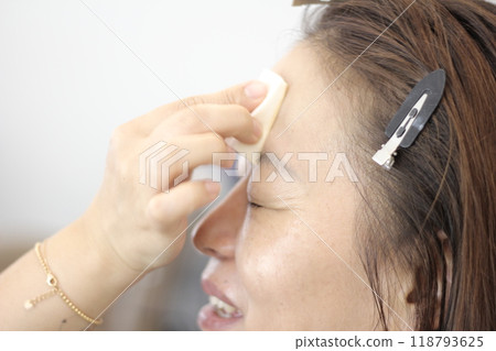 Concept of a beautiful Korean woman in her 30s getting her makeup done by a makeup artist, face before makeup Concept of a beautiful Korean woman in her 30s getting her makeup done by a makeup artist, face before makeup 118793625