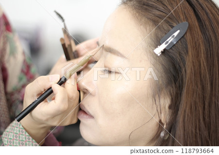 Concept of a beautiful Korean woman in her 30s getting her makeup done by a makeup artist, face before makeup 118793664