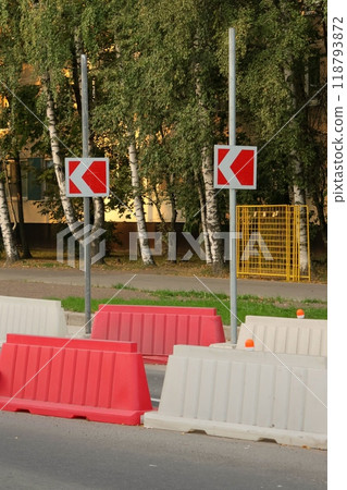Red, white plastic safety barriers along roads. Ensuring road safety with visible barriers Red, white plastic safety barriers along roads. Ensuring road safety with visible barriers 118793872