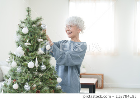 裝飾聖誕樹的資深婦女 裝飾聖誕樹的資深婦女 118794185