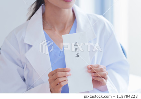 Female doctor holding a resignation letter Female doctor holding a resignation letter 118794228