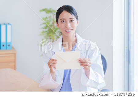 Female doctor holding a letter Female doctor holding a letter 118794229