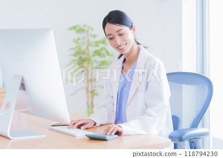 Female doctor calculating with a calculator Female doctor calculating with a calculator 118794230