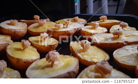 Baked potatoes in the oven. Ruddy potatoes with a piece of lard on a match. A very tasty dish. 118795527