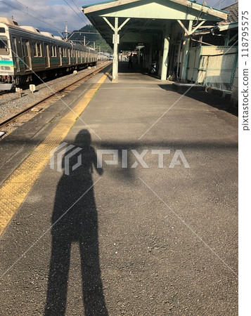 A long shadow stretches across the platform A long shadow stretches across the platform 118795575